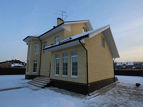 современный двухэтажный кирпичный коттеджный дом под съем на зимнем участке за забором