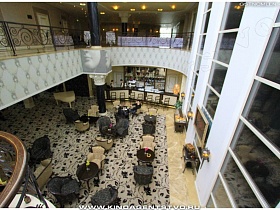 вид со второго этажа на уютное кафе в холле отеля под лестницей