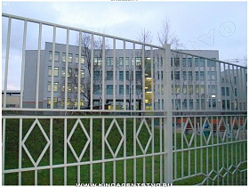 белый металлический забор вокруг школы-гимназии