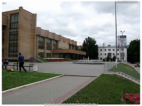 ухоженная прилегающая площадь с фонтаном и подстриженные газоны Дворца культуры Мир в Домодедово