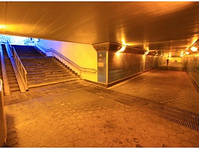 широкие ступени с перилами и пандусом в хорошо освещенный подземный переход Советского типа