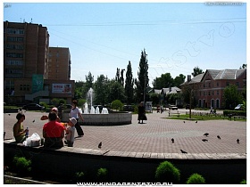чистая ухоженная площадь с отдыхающими вокруг круглого фонтана Ивантеевки
