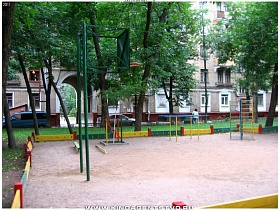 спортивные тренажеры на детской площадке двора в кирпичных пятиэтажках