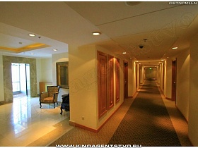 переход из холла отеля в длинный коридор с номерами