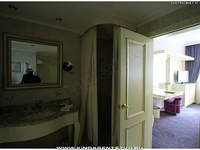 зеркало над раковиной у входной двери в красивую спальню отеля