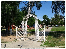 белые арочные ворота плетенной конструкции на входе в городскую площадь с детской игровой площадкой в Ивантеевке