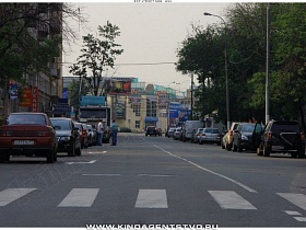 сеть бутиков и торговых центров вдоль проезжей дороги 1-го Кожуховского переулка с припаркованными машинами на обочине