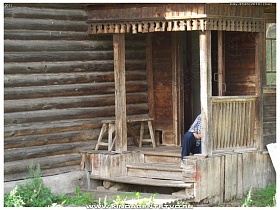 полуразрушенное деревянное крыльцо с перилами под резной крышей в Переславле