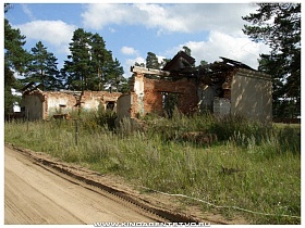 стены разрушенных домов у проселочной накатанной дороги в Переславле