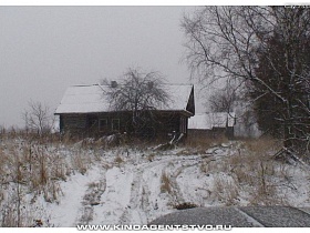 четыре деревянных дома с белым снегом на крышах вдоль улицы заброшенной деревни Тверской области