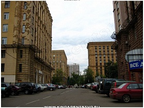 припаркованные машины у стен сталинского здания