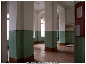 квадратные колонны в холле с зелеными панелями школы №1