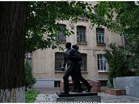 памятник студентам на постаменте во дворе института классического советского образца 80 годов с круглым спортзалом