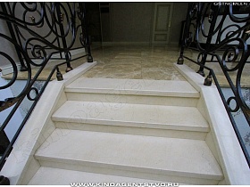 ступени лестницы с кованными перилами в красивом отеле