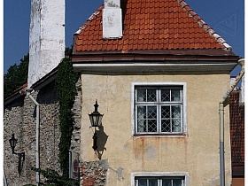 торец исторической дома с черепицей на крыше