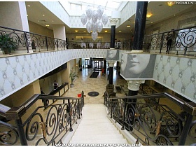 вид на ресепшн и выход с отеля с лестницы с красивыми коваными перилами