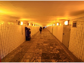 обычный длинный подземный переход советского стиля с многочисленными светильниками с решеткой под потолком