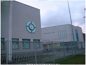 круглые часы в красивом оформлении на стене школы-гимназии