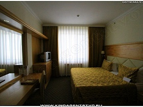мягкое ковровое покрытие в спалне с большим окном в гостиничном номере