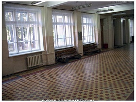 просторный светлый холл школы с большими окнами и разноцветной плиткой на полу