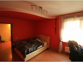 синее цветное покрывало на бежевой кровати в розовой зоне спальни трехкомнатной квартиры