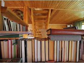 многочисленные книги на полках между двумя деревянными балками, разделяющими комнату на две зоны современной двухэтажной даче музыканта