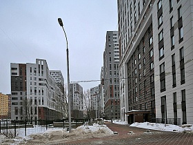 бетонные оградительные полусферы на брусчатой дороге в красивый современный двор новостроек