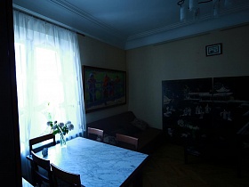 ваза с розами на светлом мраморном прямоуголном столе у окна с белой гардиной в гостиной квартиры художника