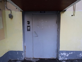 серые металлические входные двери с домофоном и под навесом в подъезд 4 дома, требующего ремонта эпохи СССР
