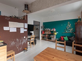 белые листы с нужной информацией на коричневой стене с открытой нишей в зонированой кухне с элементами лофт современной квартиры