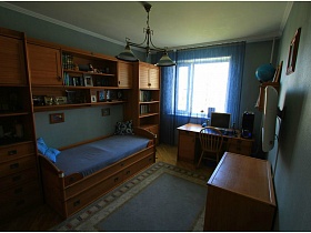 голубые шторы, ковер, люстра и матрас кровати в спальне с голубыми стенами трехкомнатной квартиры