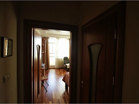 деревянные двери с фигурными рифлеными стеклами в комнаты просторной современной квартиры с балконами
