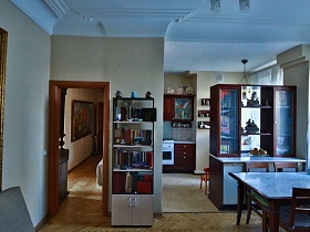 общий вид гостиной с высокими потолками, совмещенной с кухней стильной квартиры художника в сталинке