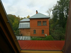 яркая семейная классическая дача на зеленом участке из окна соседнего домика
