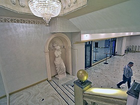 Красивая хрустальная люстра в мраморном белом торжественном зале, золотая лестница