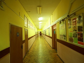 длинный школьный коридор желтого цвета на одном из этажей школы