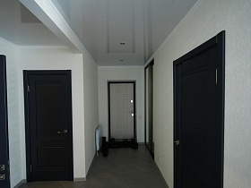 обувь на коврике у входной двери в светлую прихожую с черными межкомнатными дверьми стильной дачи в стиле скандинавский минимализм