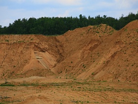 горы песка с проросшей травой в песчаном заброшенном карьере в лесной зоне для аренды для съемок кино