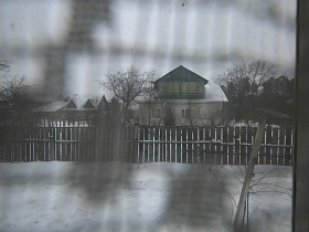 вид из окна через гардину на соседний дачный дом