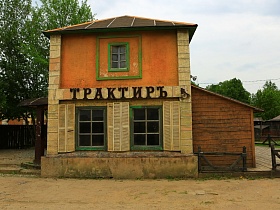 броская вывеска "трактир" на стенах двухэтажного дома с высоким цоколем на одной из улиц старого городка для съемок кино