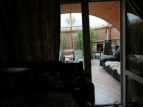 открытая дверь со спальни на застекленный уютный балкон с зеленым уголком на семейной классической даче