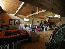 бра на ножке над кроватью с цветным ярким покрывалом в спальной зоне деревянного домика на дачном участке