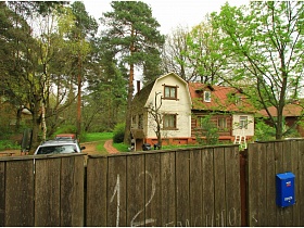 большой участок дачи в 2 дома за высоким деревянным неокрашенным забором с синим почтовым ящиком на воротах для съемок кино