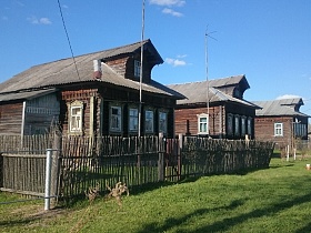 однотипные бревенчатые деревянные дома-срубы с чердачным окном в треугольной крыше и небольшой верандой