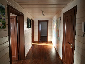 видеодомофон у двери в светлом холле с яркими картинами на стене современного деревянного дома