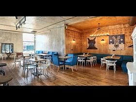 уютный уголок в кафе лофт с синими диванчиками и люстрой, стелизованной под старину