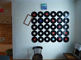 декоративное панно из круглых черных пластинок на белой стене синей кухни красивой современной квартиры художника