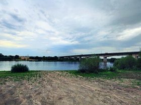 высоченный областной мост через широкую реку с песчанным пляжем, островками зеленых кустов и травы