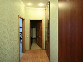 светлый коридор с встроенным книжным шкафом в трехкомнатной квартире