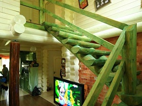 картины на светлой стене над зеленой деревянной лестницей-сруб на второй этаж темной дачи